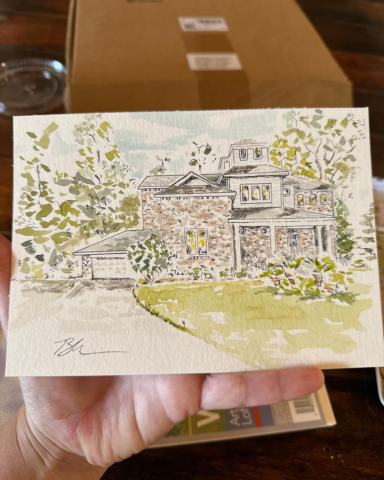 Signed watercolor and ink portrait of a two-story stone house with trees and a curved lawn